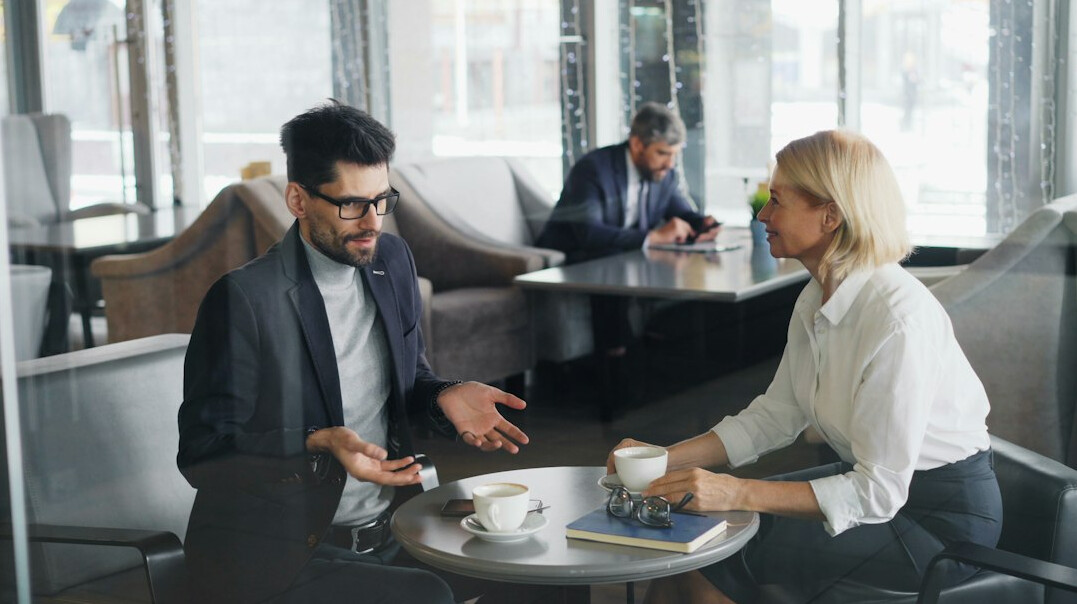 two professionals talking over coffee